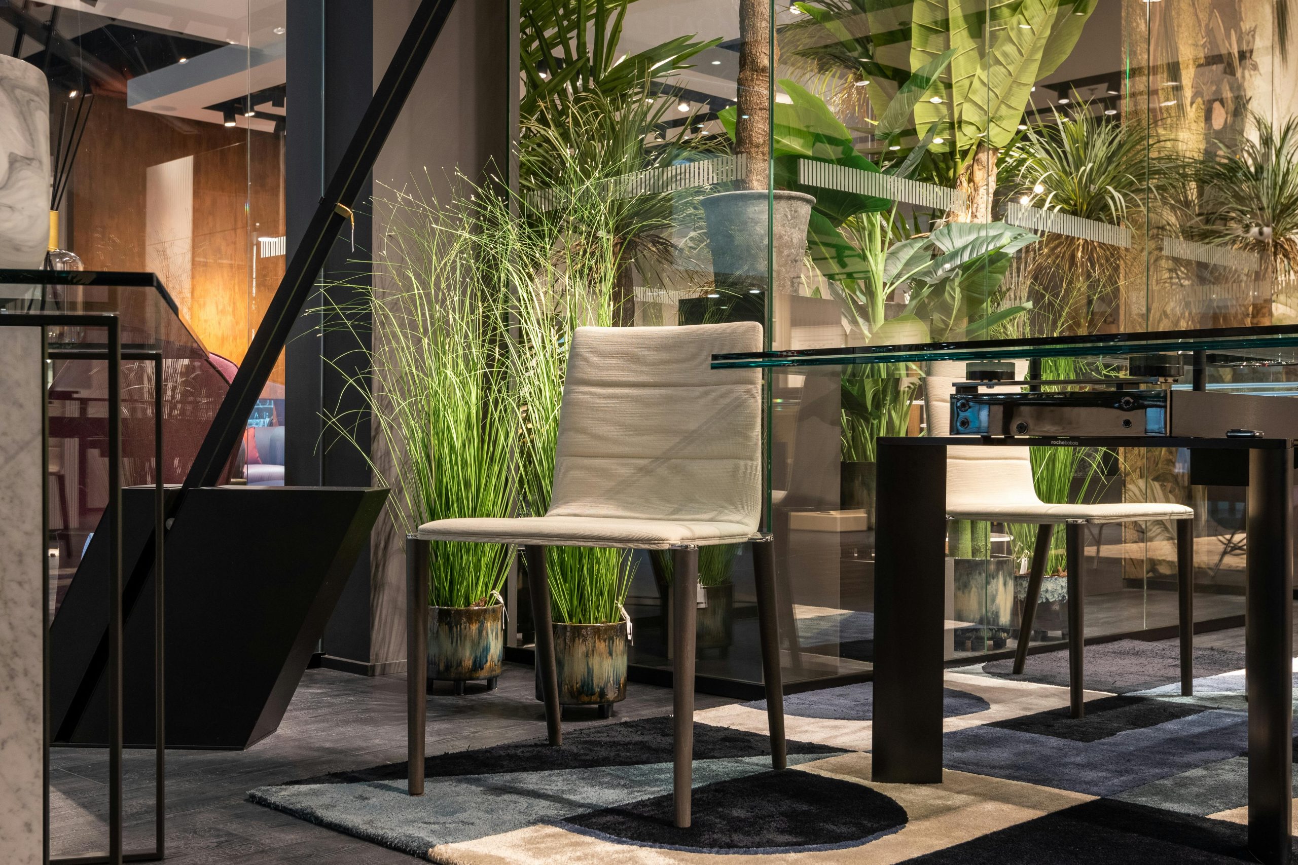 Stylish dining area featuring modern furniture and lush indoor plants, creating a cozy atmosphere.